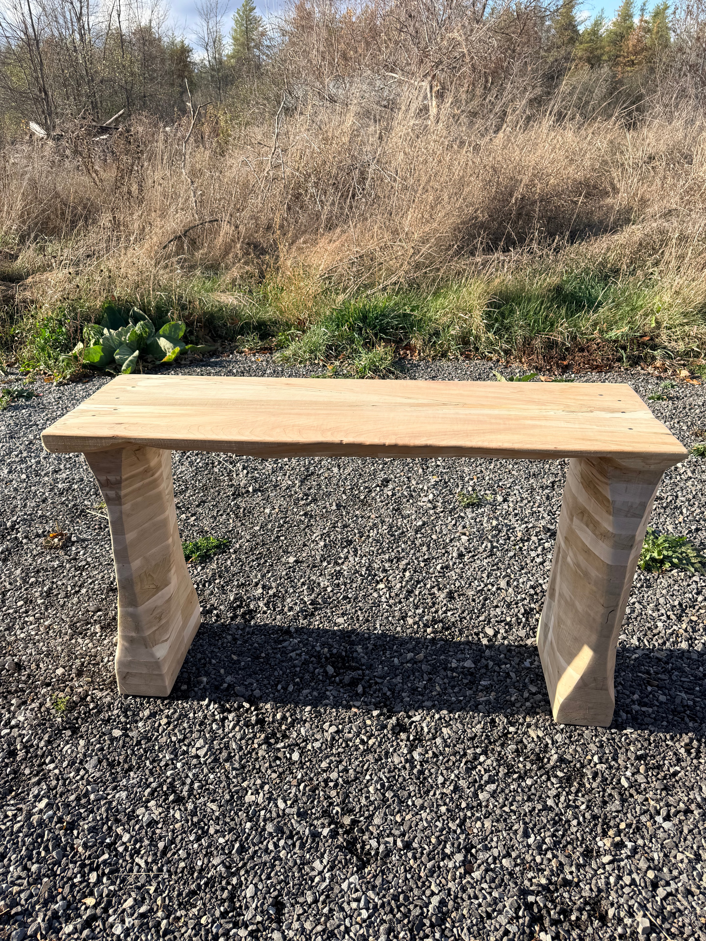 Live-edge solid wood bench with sculpted legs